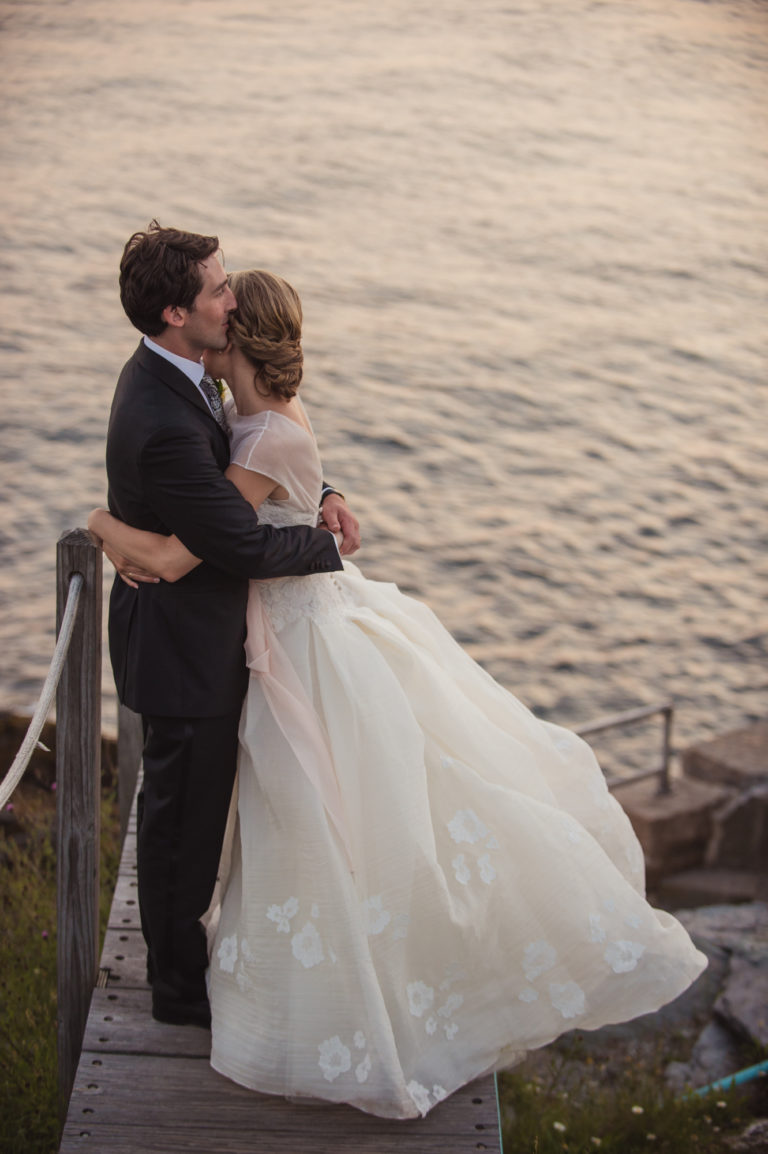 Bride and groom embrace at the lighthouse by Castle Hill Inn Newport RI