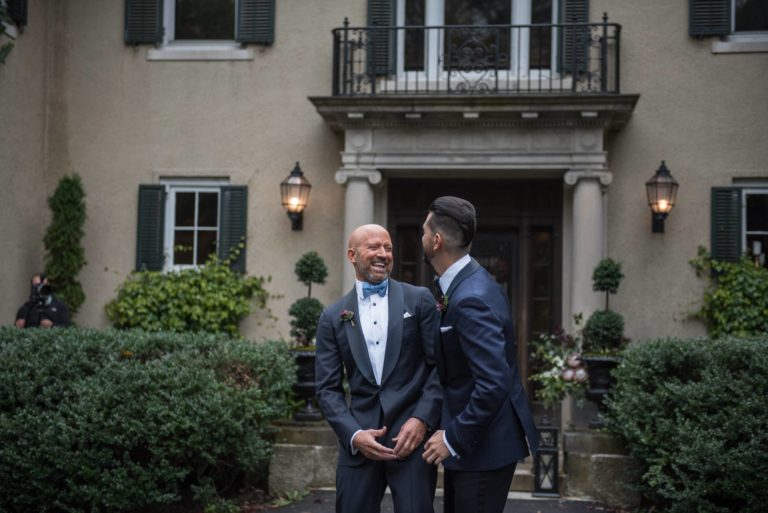 Two grooms during their first look at Lord Thompson Manor wedding in CT