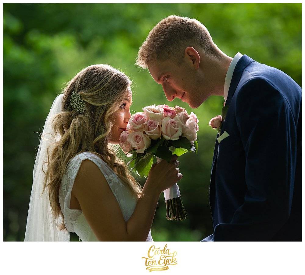 A bride smells her pink rose wedding bouquet with her new Groom at Wright's Mill Farm, Canterbury CT