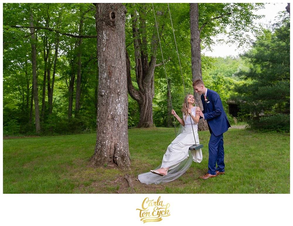 Groom pushes his new wife on a tree swing at Wright's Mill Farm in Canterbury CT