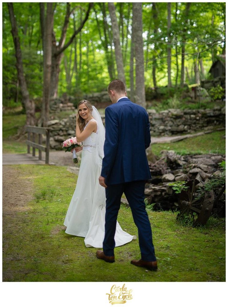 Bride looking back while walking in a mossy wood at Wright's Mill Farm, Canterbury CT