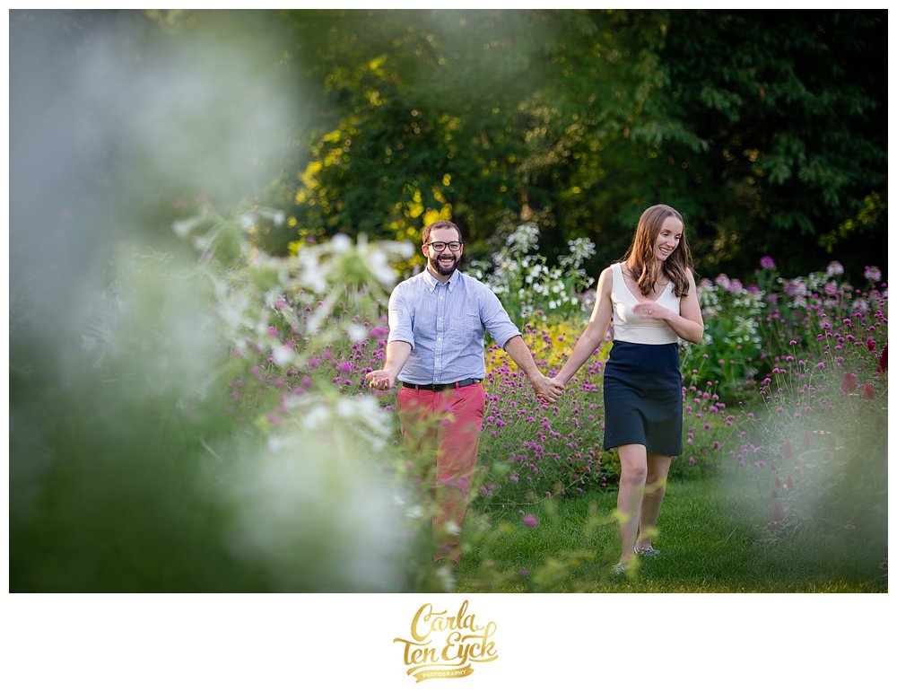 Couple laughs during their engagement session in the flower gardens at Hartford's Elizabeth Park