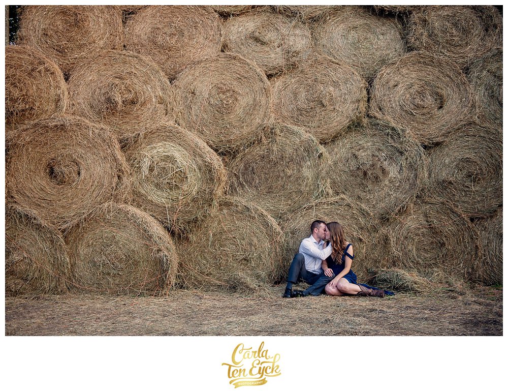 Couple by the hay bales at their engagement session at Heritage Homestead in Northford CT