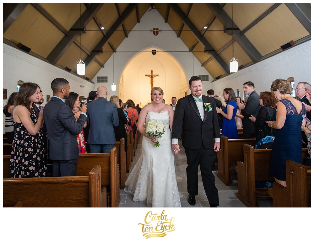 Happy bride and groom exit the church on their wedding day in Lordship CT
