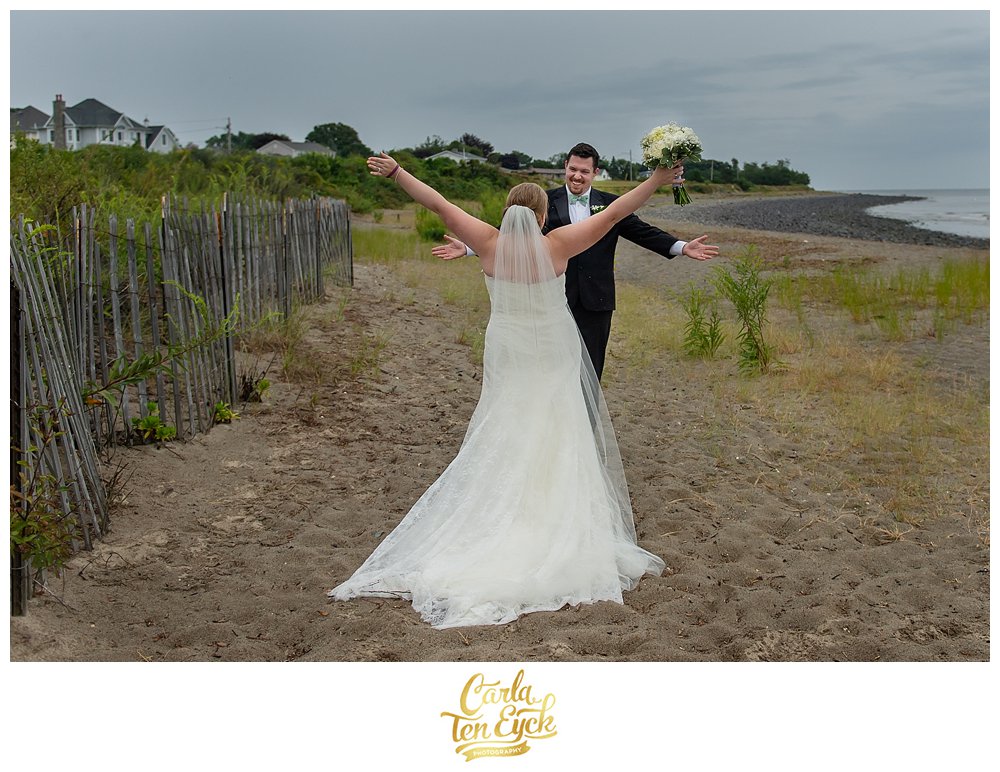 Bride and groom happily embrace on their wedding day in Lordship CT on the beach