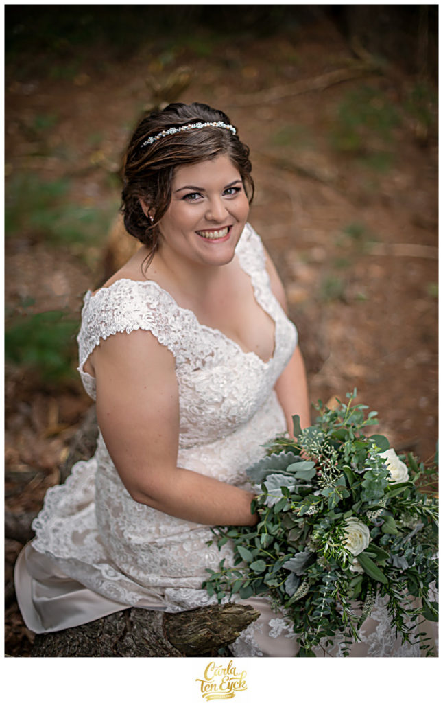 Happy bride in her lace wedding gown and her greenery wedding bouquet at her wedding in Glastonbury CT