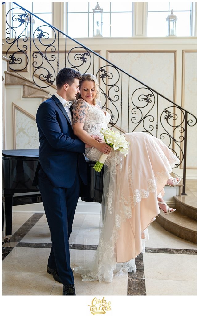 Bride and groom cuddle on a piano at their wedding at Aria in Prospect CT