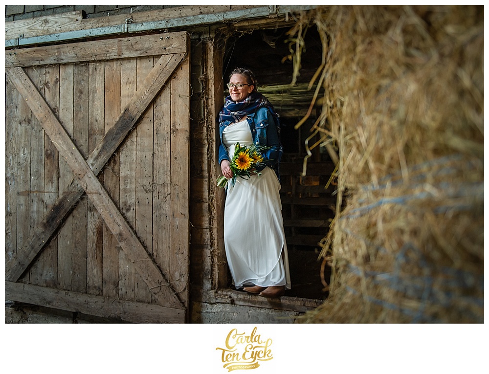 Bride stands in a barn at Cold Spring Farm at her wedding in Colchester CT