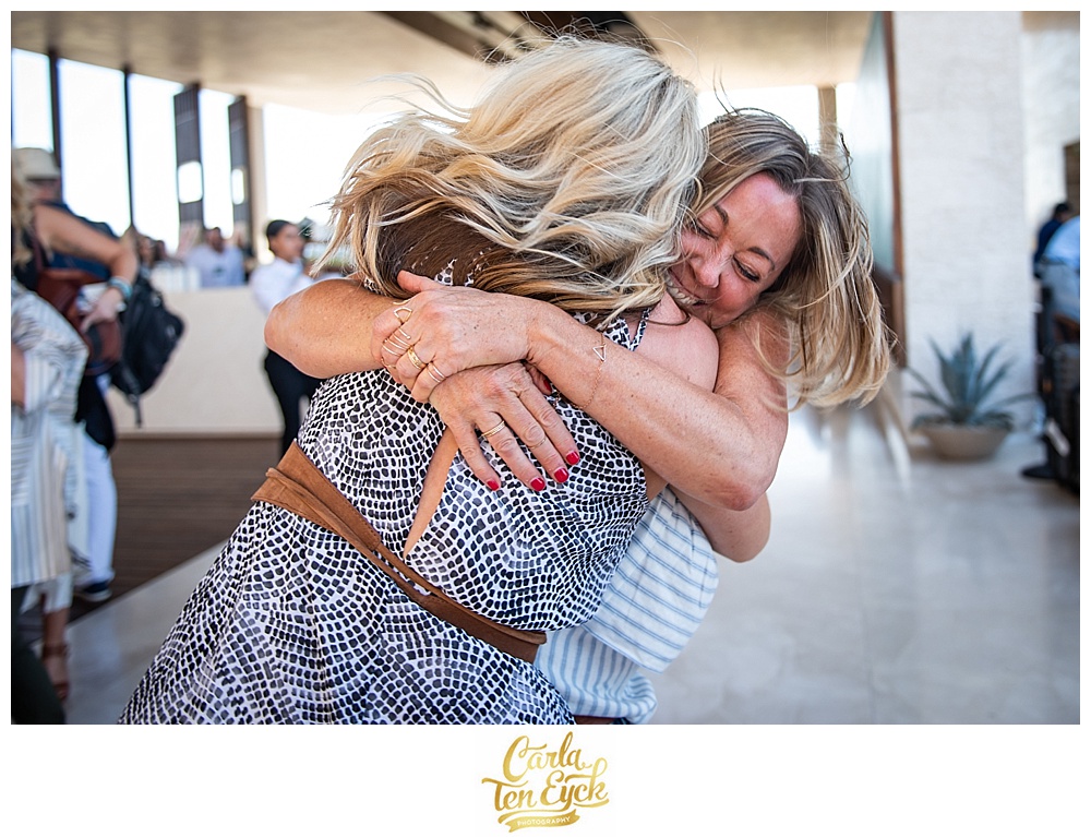 Friends joyfully embrace at the Engage Summit at the Solaz Resort in Cabo San Luca Mexico