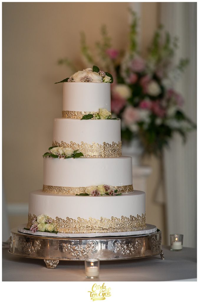 Gold and white wedding cake by DiMare Pastry Shop at a wedding at Le Chateau in South Salem Ny