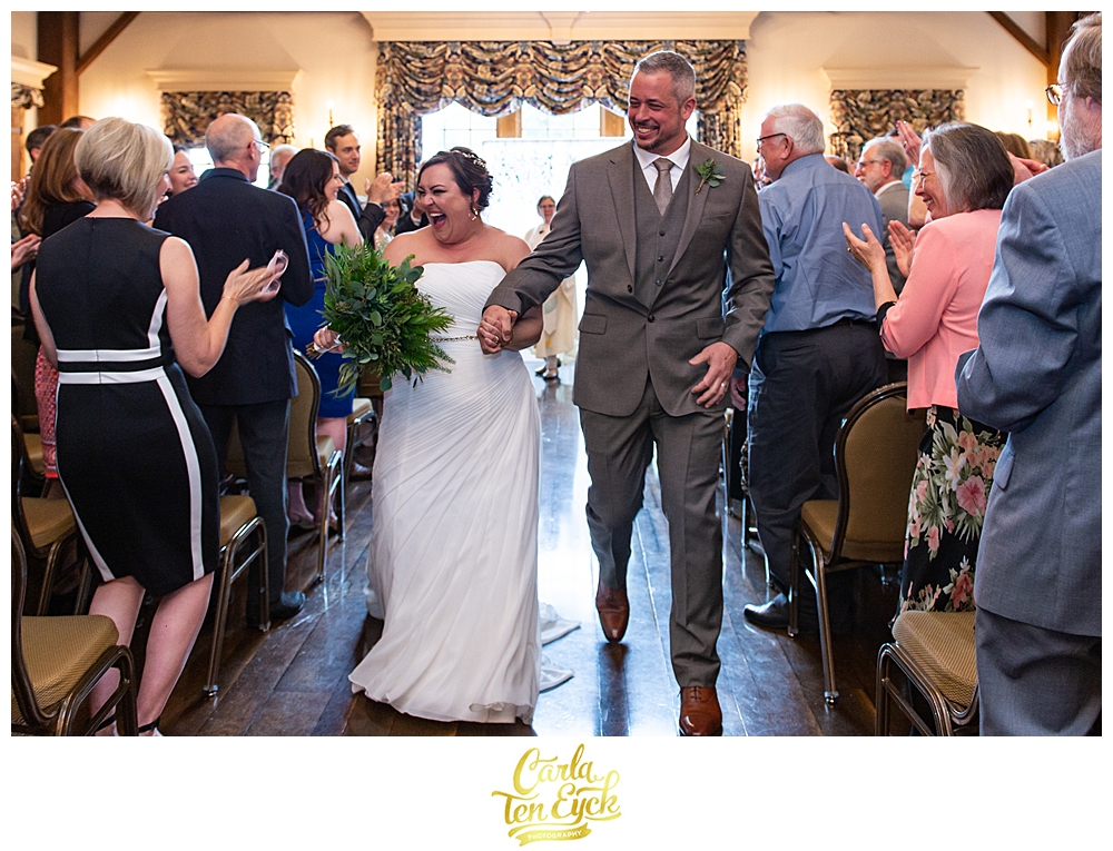 Bride and groom walk joyfully down the aisle at their wedding at the Publick House in Sturbridge MA