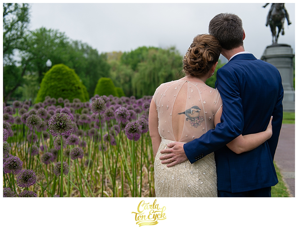 Bride and groom snuggle by the purple allium in the Boston Public Gardens in Boston MA