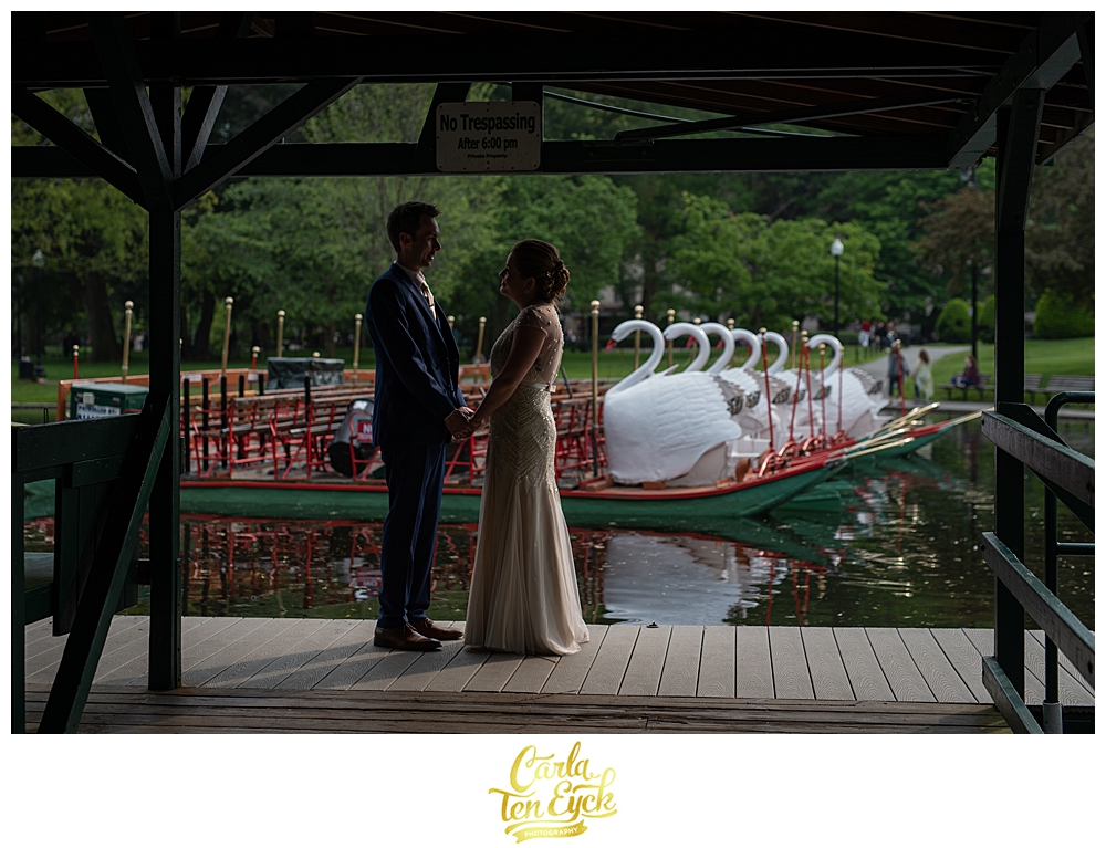 Bride and groom by the swan boats in the Boston Public Gardens in Boston MA