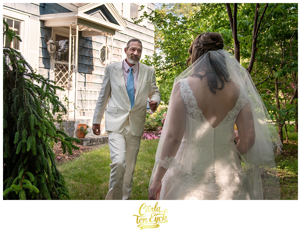 Groom sees his bride during their first look at their backyard wedding in CT
