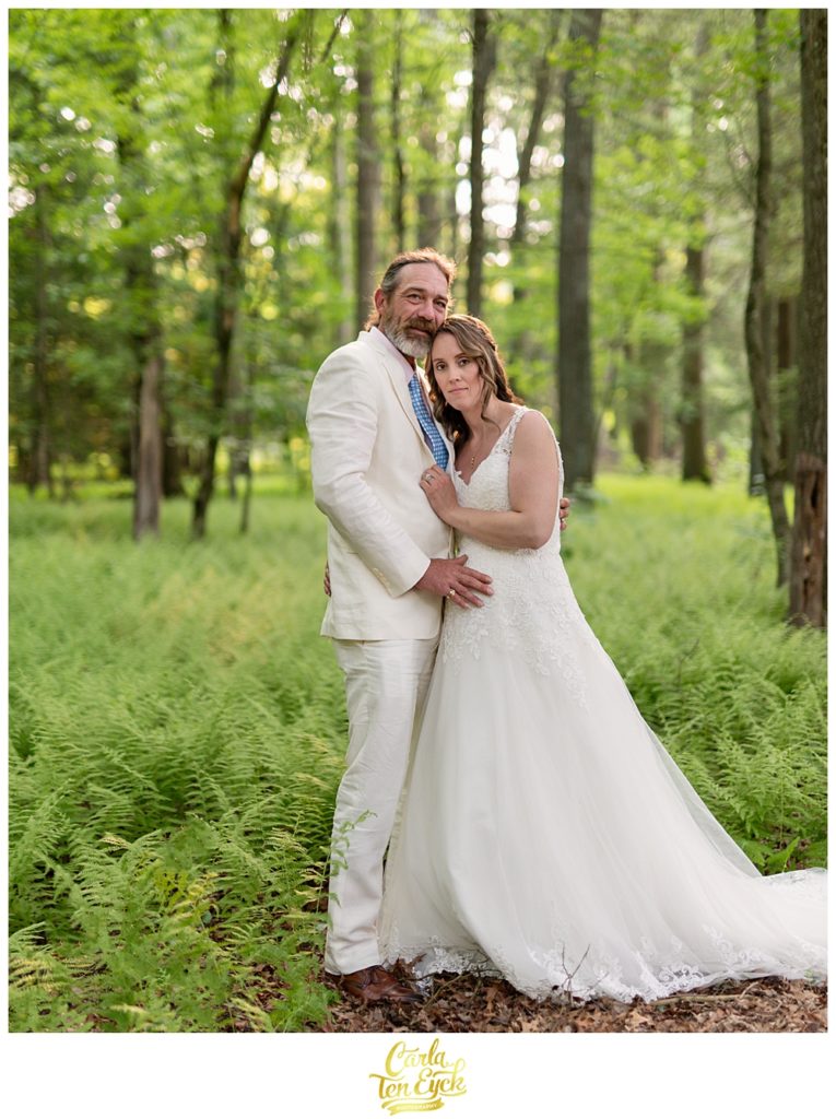 Happy bride and groom in a grove of ferns after their backyard CT wedding 
