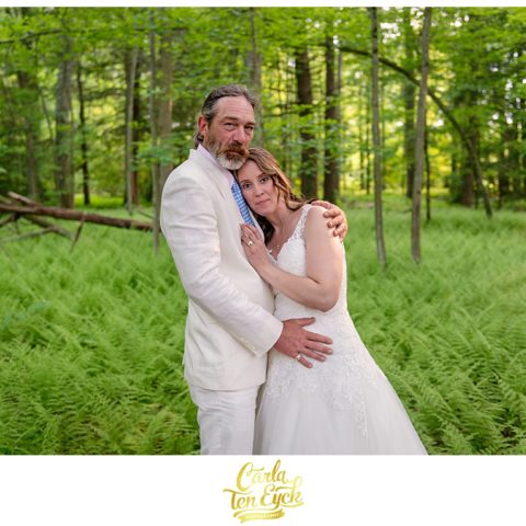 Bride and groom in a grove of ferns on their wedding day