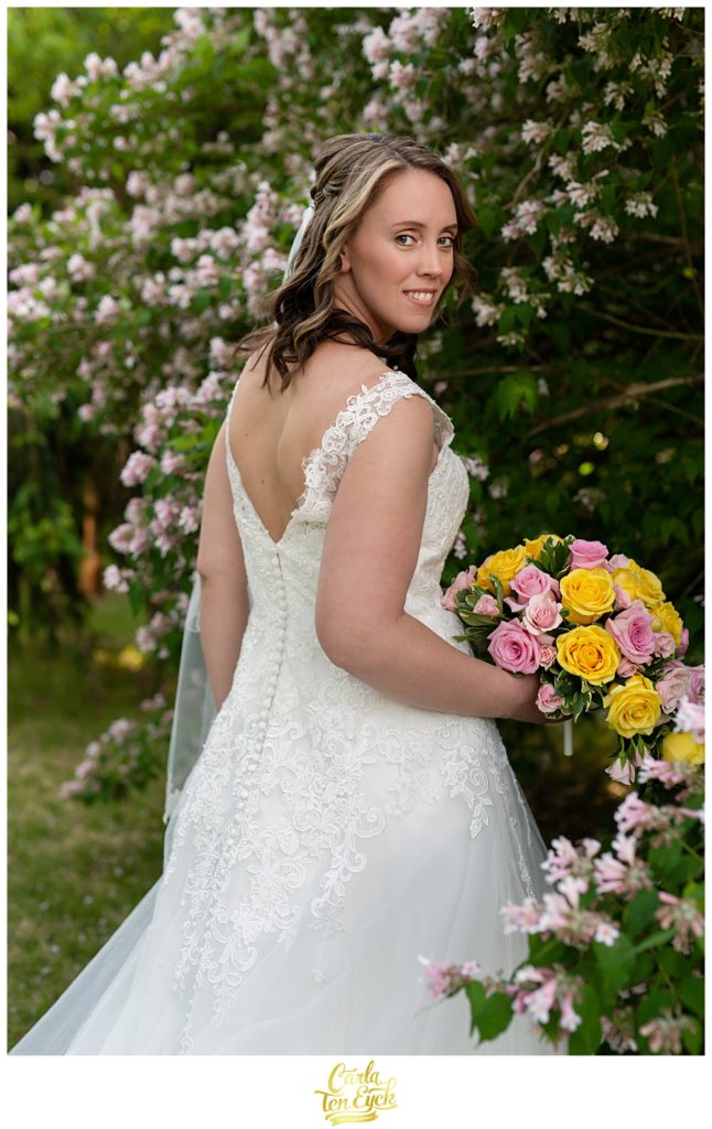 Bride poses for pictures at her CT backyard wedding in her lace wedding gown