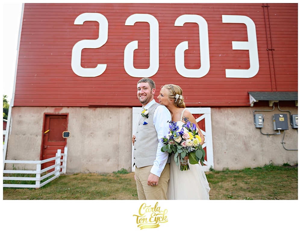 Bride and groom in front of the backward EGGS sign Flamig Farm Simsbury CT
