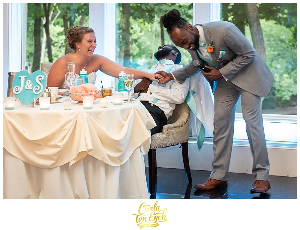 A groom laughs during a toast at his wedding at The Riverview in Simsbury CT