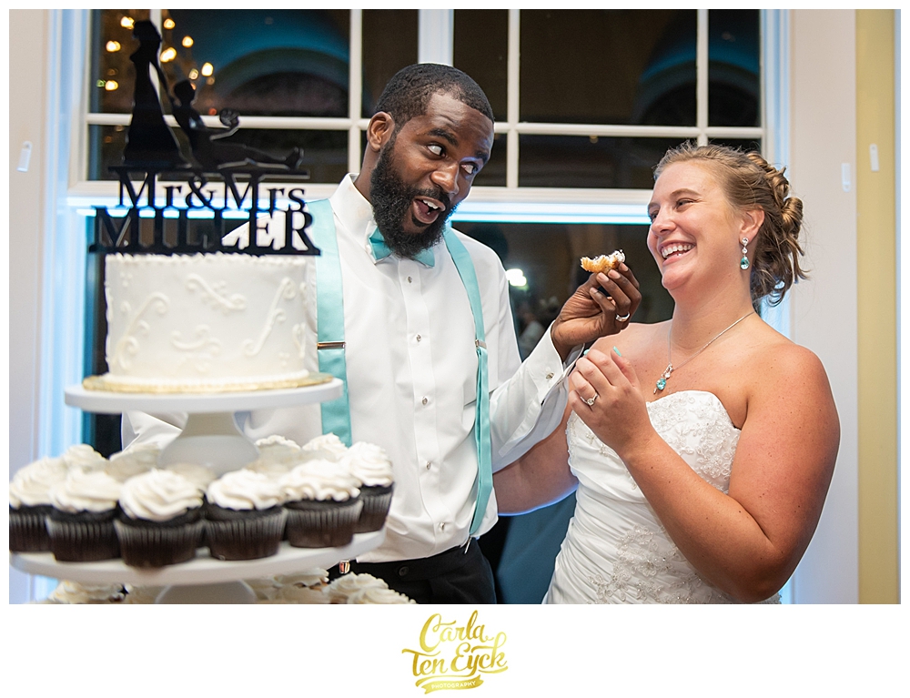 A bride and groom cut their cake at their wedding at the Riverview in Simsbury CT