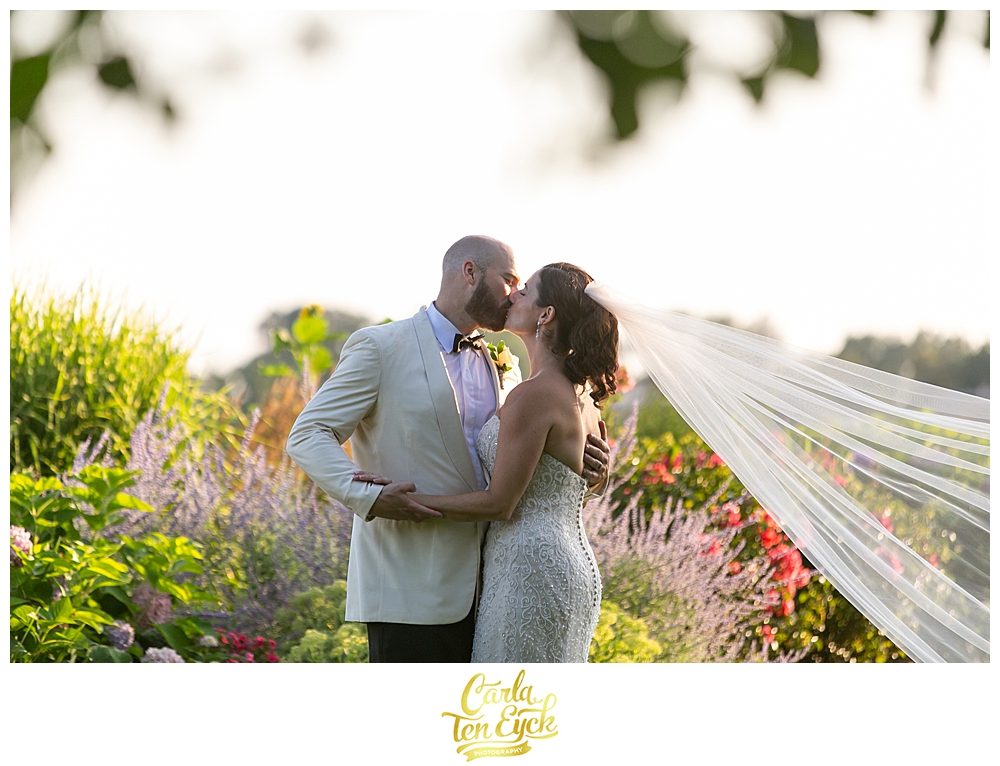 Bride and groom kiss in the garden at their wedding at The Owenego Inn in Branford CT