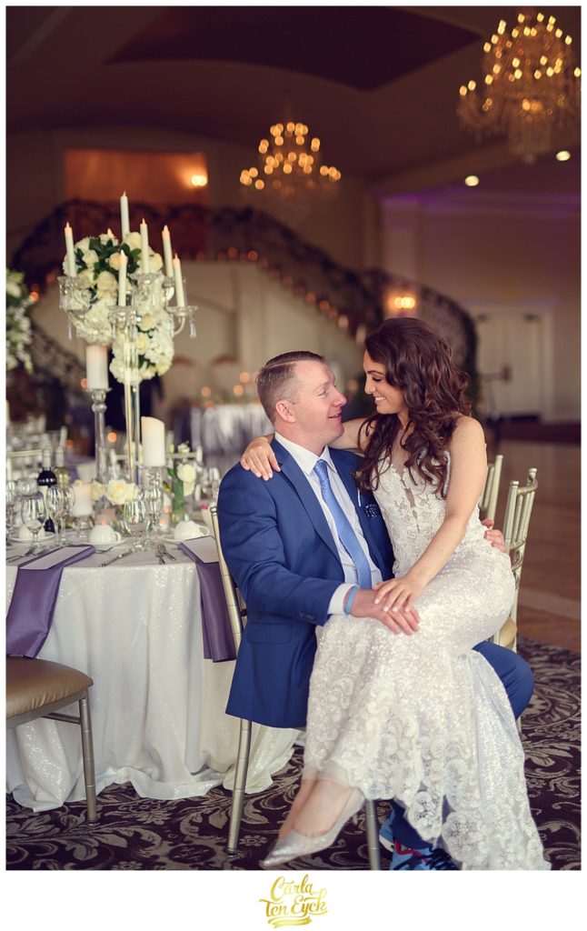A bride and groom snuggle in the ballroom at their wedding at Aria in Prospect CT