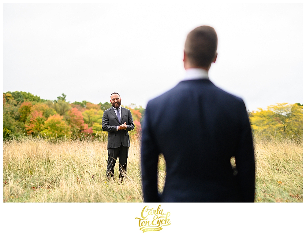A groom smiles at his husband at their wedding at the Eustis Estate in Milton MA
