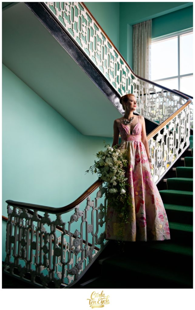 A bride poses on the colorful stairway at The Greenbrier in West Virginia