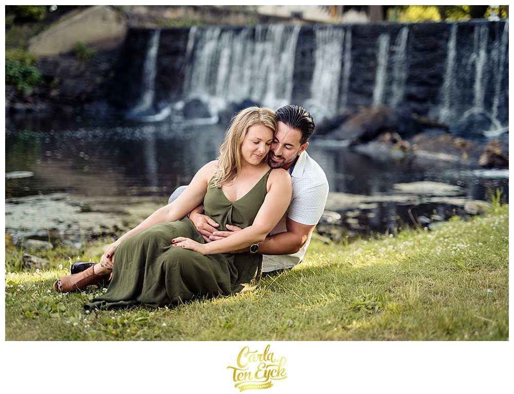 A couple snuggles by the waterfall during their Milford Ct engagement session