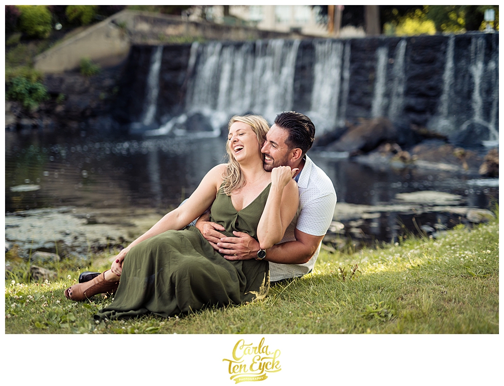 A couple laughs by the waterfall during their Milford CT engagement session