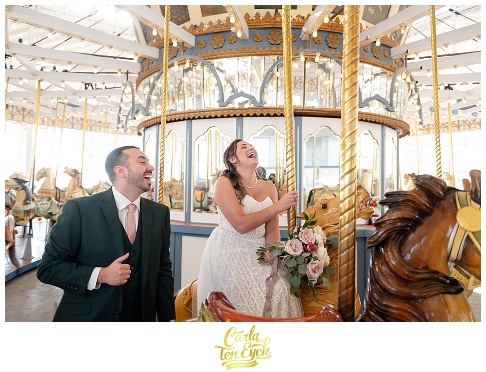 A bride and groom pose on the carousel for photos at their wedding at Lighthouse Point Park in New Haven CT 