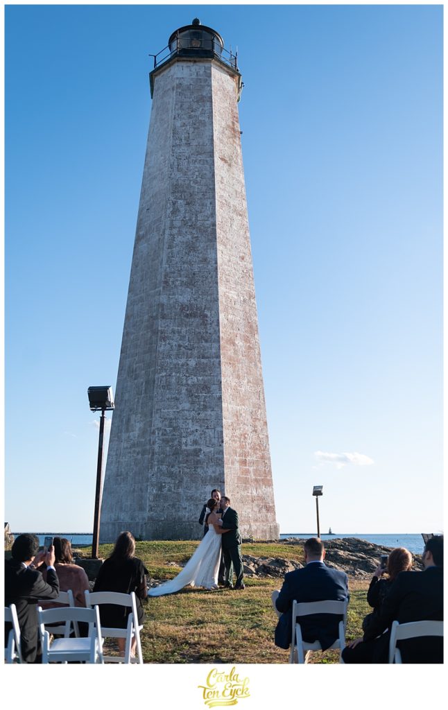 A bride and groom during their wedding ceremony at The Lighthouse at Lighthouse Point Park in New Haven CT 