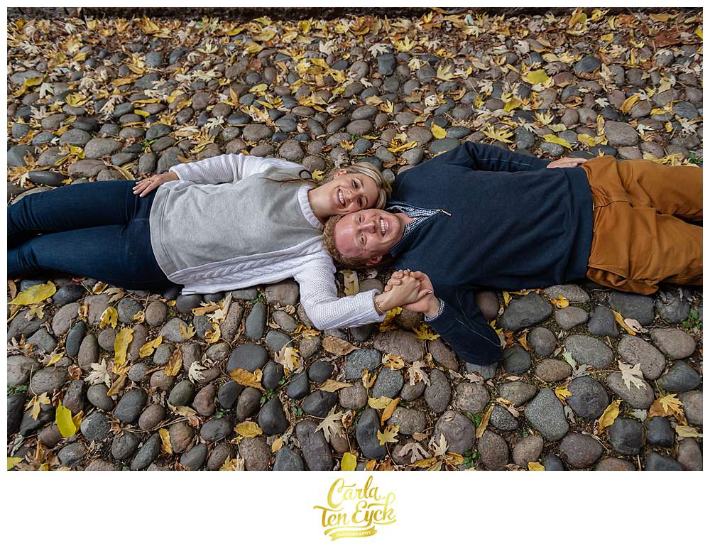 A couple lies on famous Acorn Street during their Boston engagement session