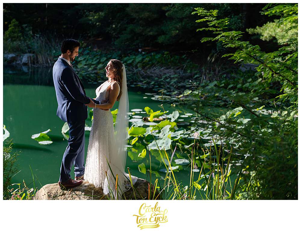 A bride laughs by the pond at her wedding at Chatfield Hollow Inn Killingworth CT