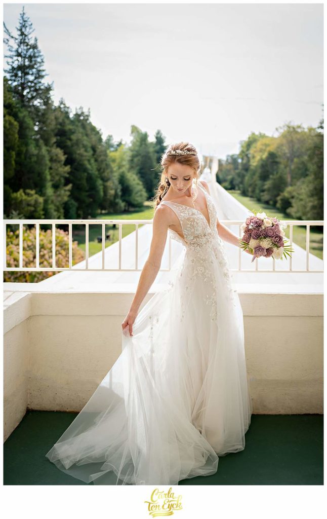 A bride on the balcony at her wedding cuddling Covid at The Wadsworth Mansion at Long Hill, Middletown CT