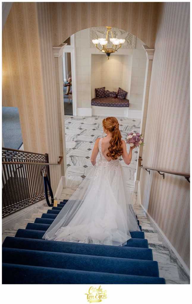 A bride walks down the stairs during her wedding during Covid at The Wadsworth Mansion at Long Hill, Middletown CT