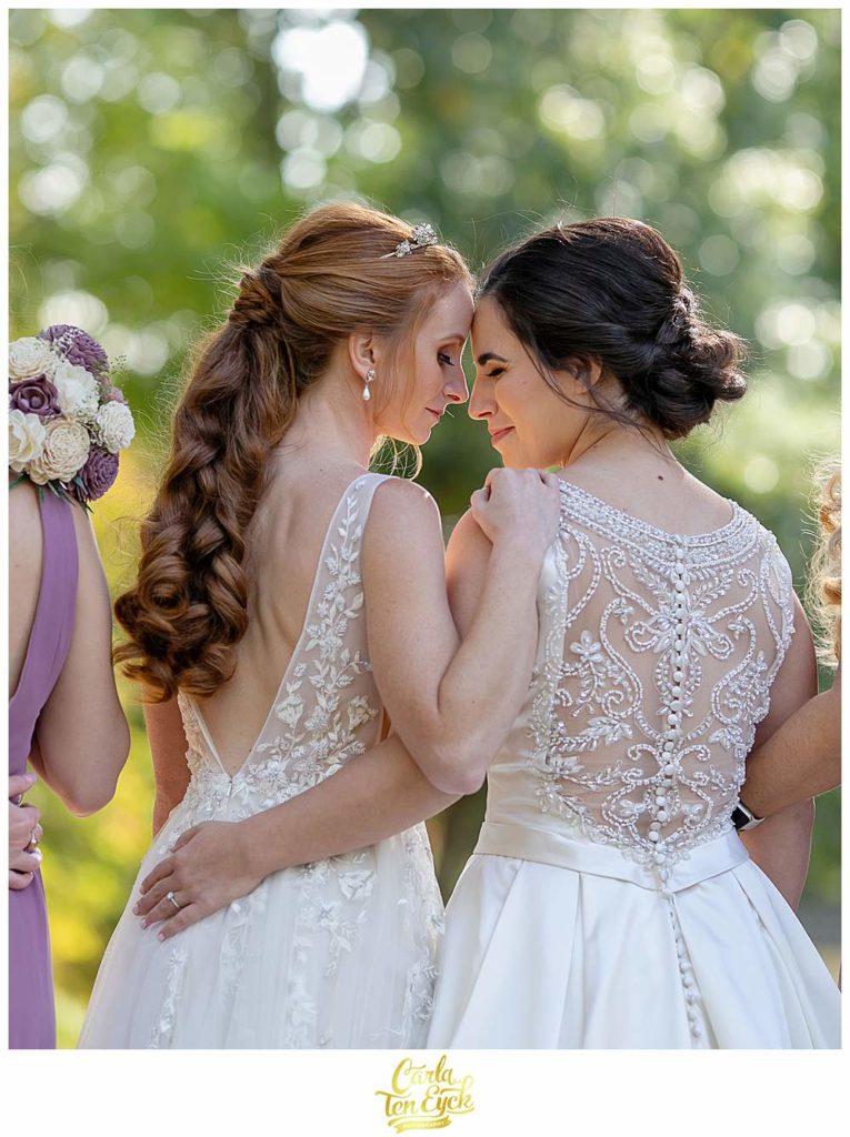 Two brides snuggle during their wedding photos at their wedding at The Wadsworth Mansion, Middletown CT