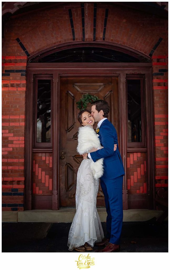 A couple embraces by the front door on their wedding day at The Mark Twain House in Hartford CT