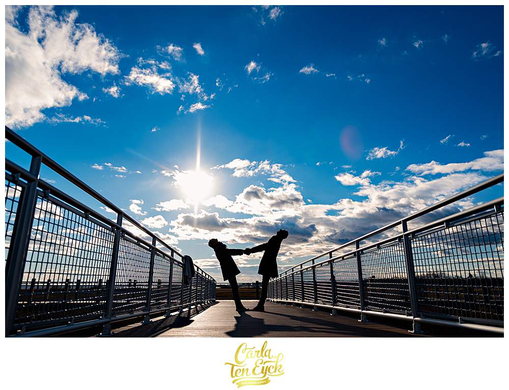 two grooms pose for photos on the boardwalk at Silver Sands beach in Milford CT