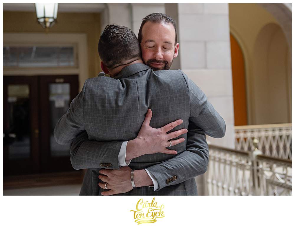 Two grooms hug during their elopement at Hartford City Hall in Hartford CT