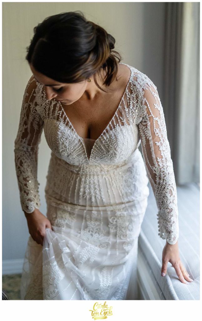 A bride puts on her wedding gown by Pronovias at her wedding in Irvington NY