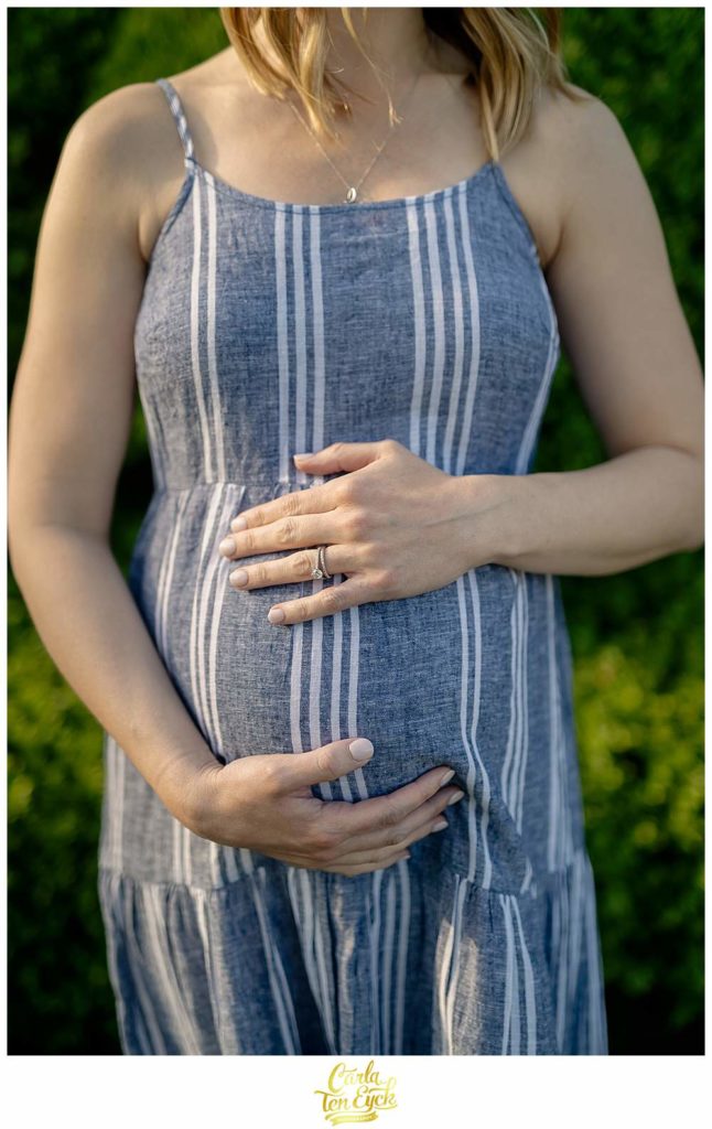 A mom holds her belly during her Harkness maternity session, Harkness Park Waterford CT