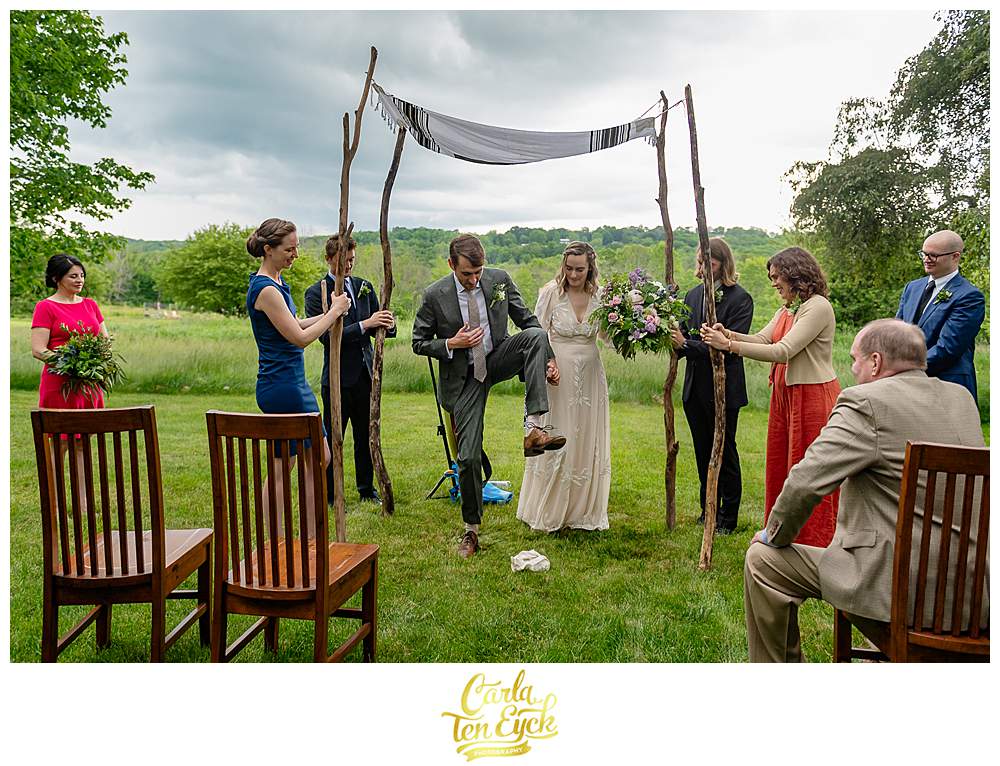 A groom breaks the glass during their Jewish Litchfield wedding in a family backyard in Litchfield CT