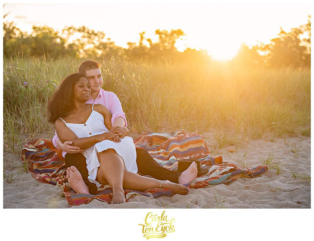 A couple snuggles during sunset at their Milford Audubon Society engagement session in Milford CT