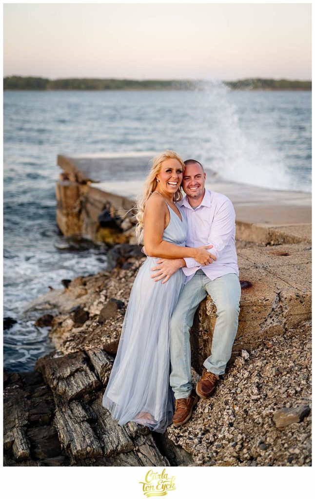 A couple poses on the rocks at Great Island Common during their Portsmouth New Hampshire engagement session