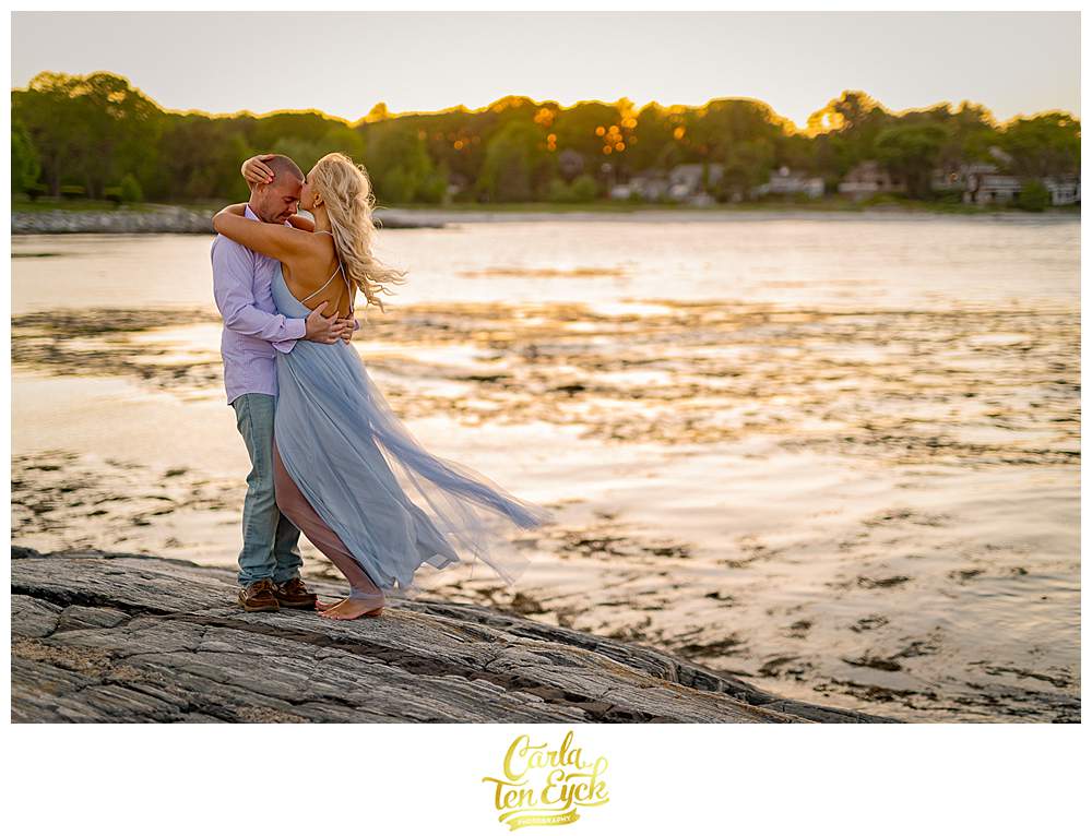 A couple poses on the rocks at Great Island Common during their Portsmouth New Hampshire engagement session