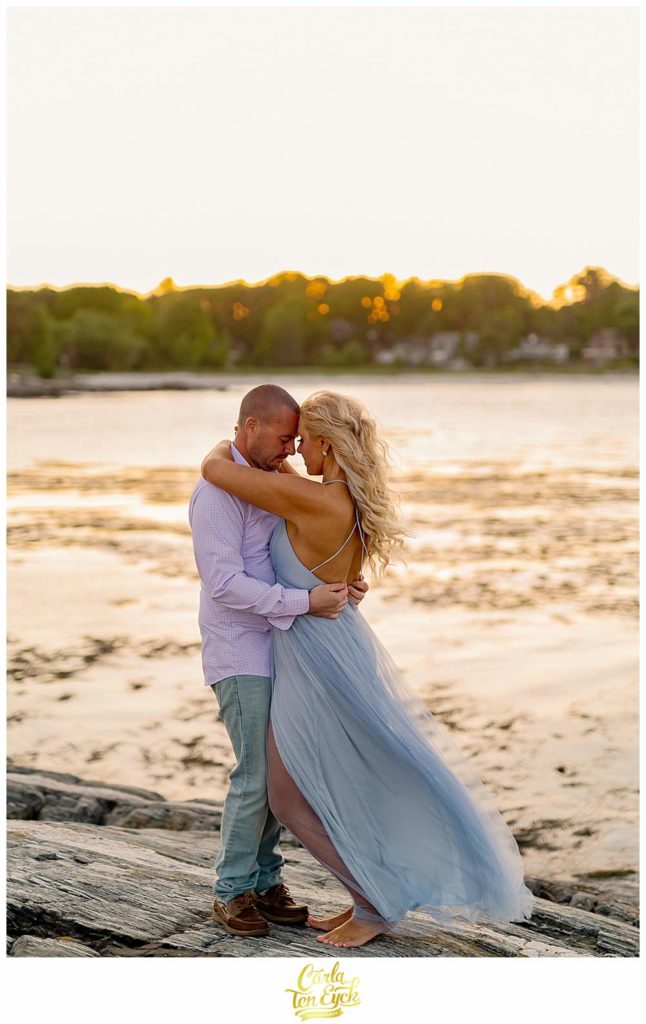 A couple poses on the rocks at Great Island Common during their Portsmouth New Hampshire engagement session