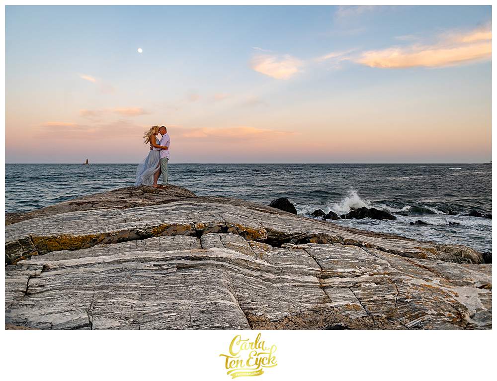 A couple poses on the rocks at Great Island Common during their Portsmouth New Hampshire engagement session