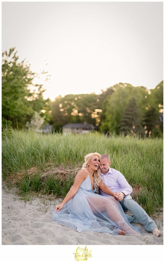 A couple laughs at Great Island Common in Portsmouth New Hampshire during their engagement session