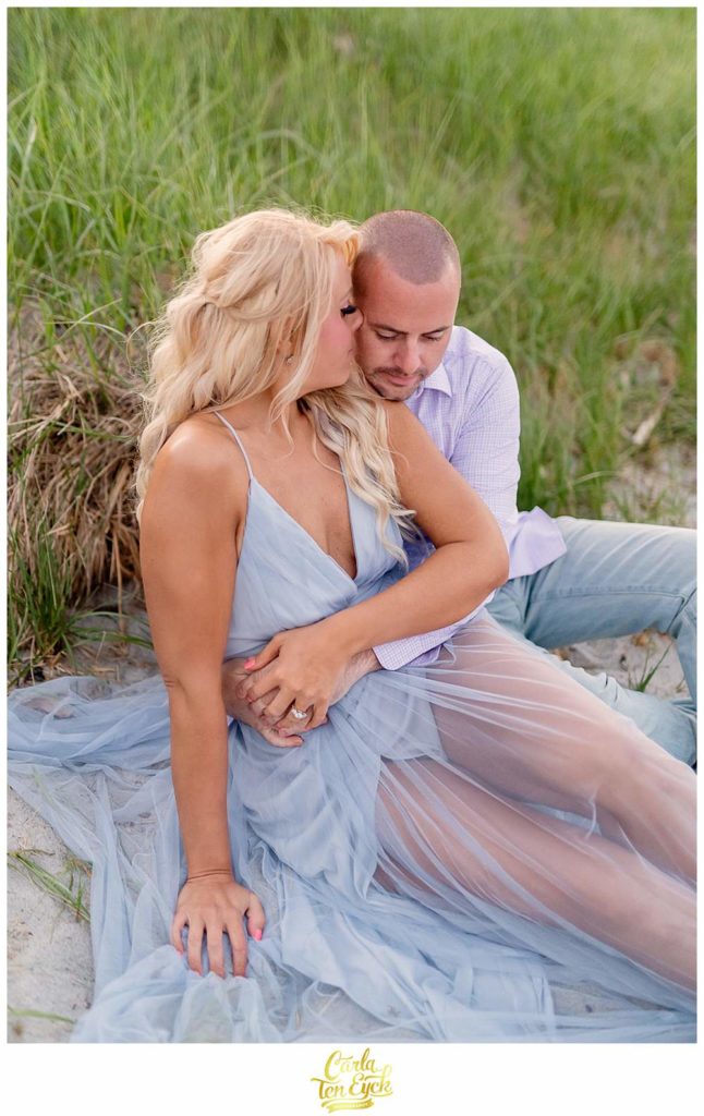 A couple cuddles on the beach during their Portsmouth New Hampshire engagement session